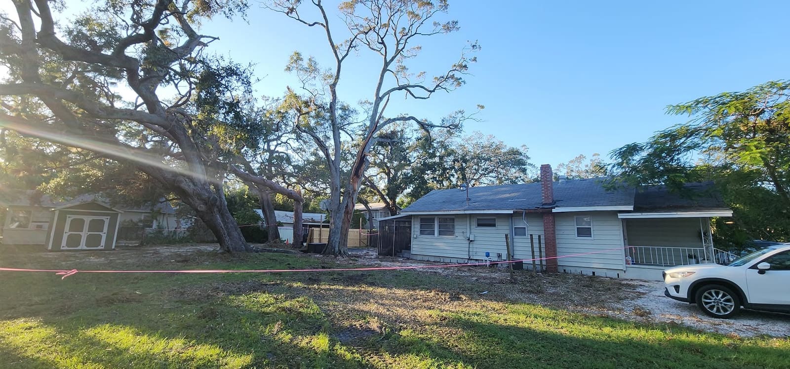 Large oak limbs down beside a house after a storm